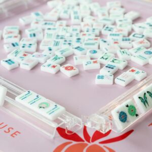 Mahjong tiles on a pink mat
